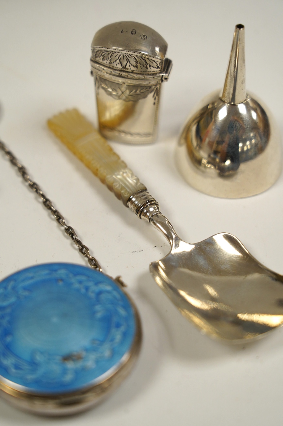 Five assorted small silver items including an early 19th century silver scent bottle case by Samuel Pemberton, containing a small glass flask, a mother of pearl handled caddy spoon, a silver whistle, a small funnel and a